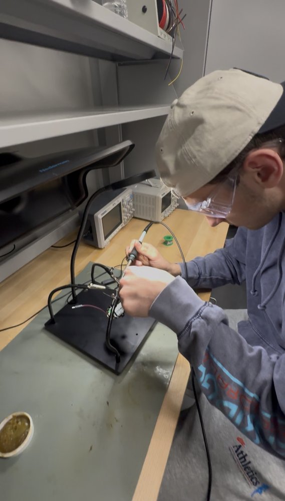 Teagan soldering a circuit board in a lab